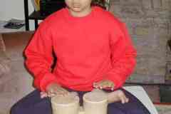 Jamie perched on a small table in the lotus position playing the bongoes!